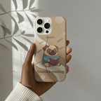 Hand holding beige iPhone case with cute pug reading book design, aesthetic gift for book loving moms