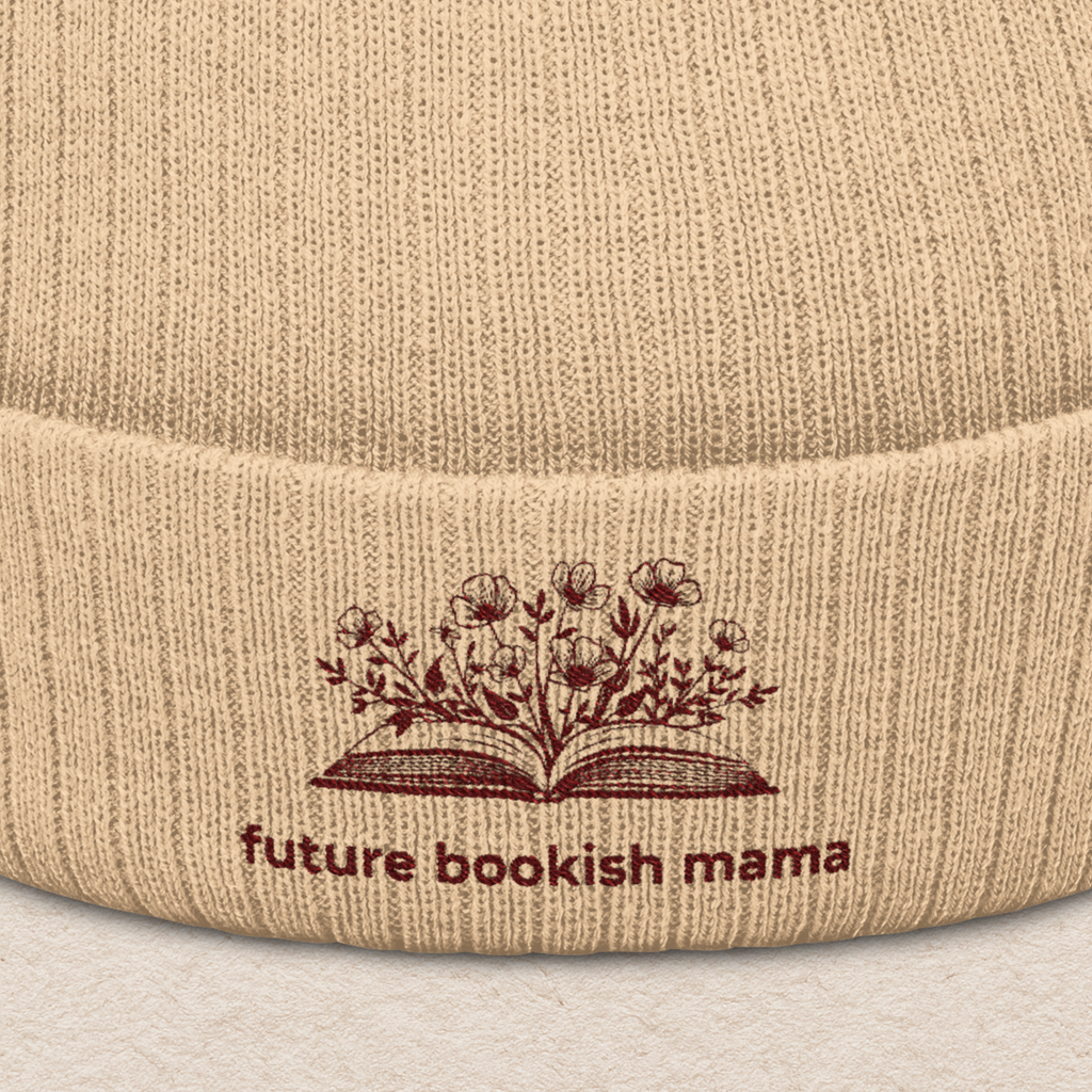 Close-up embroidery detail of “Future Bookish Mama” text and book design on beige knit beanie