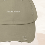 Close-up of “Future Mama” text on distressed light olive baseball cap