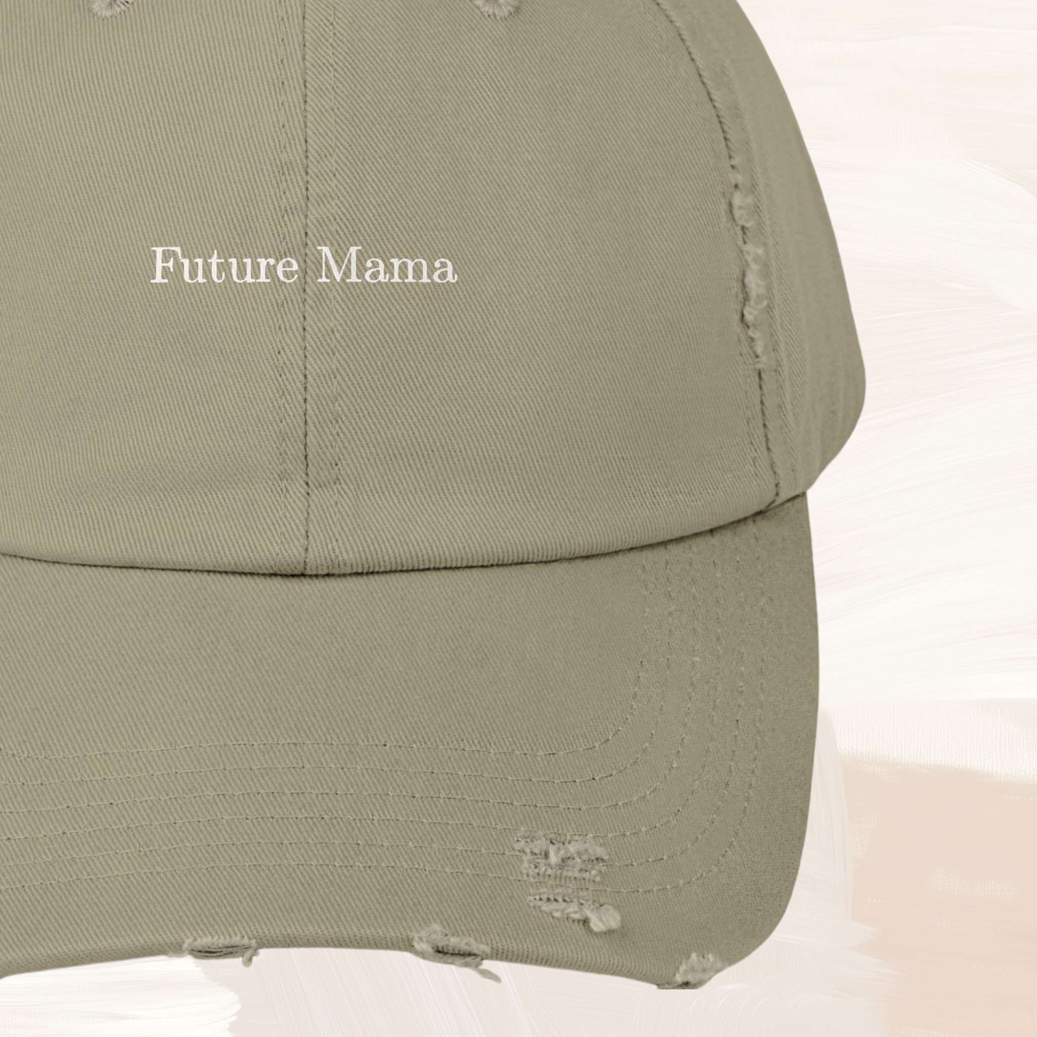 Close-up of “Future Mama” text on distressed light olive baseball cap