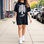 Halloween pregnancy reveal shirt featuring skeleton baby bump graphic in black