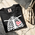 Folded Halloween pregnancy reveal shirt with skeleton baby bump graphic
