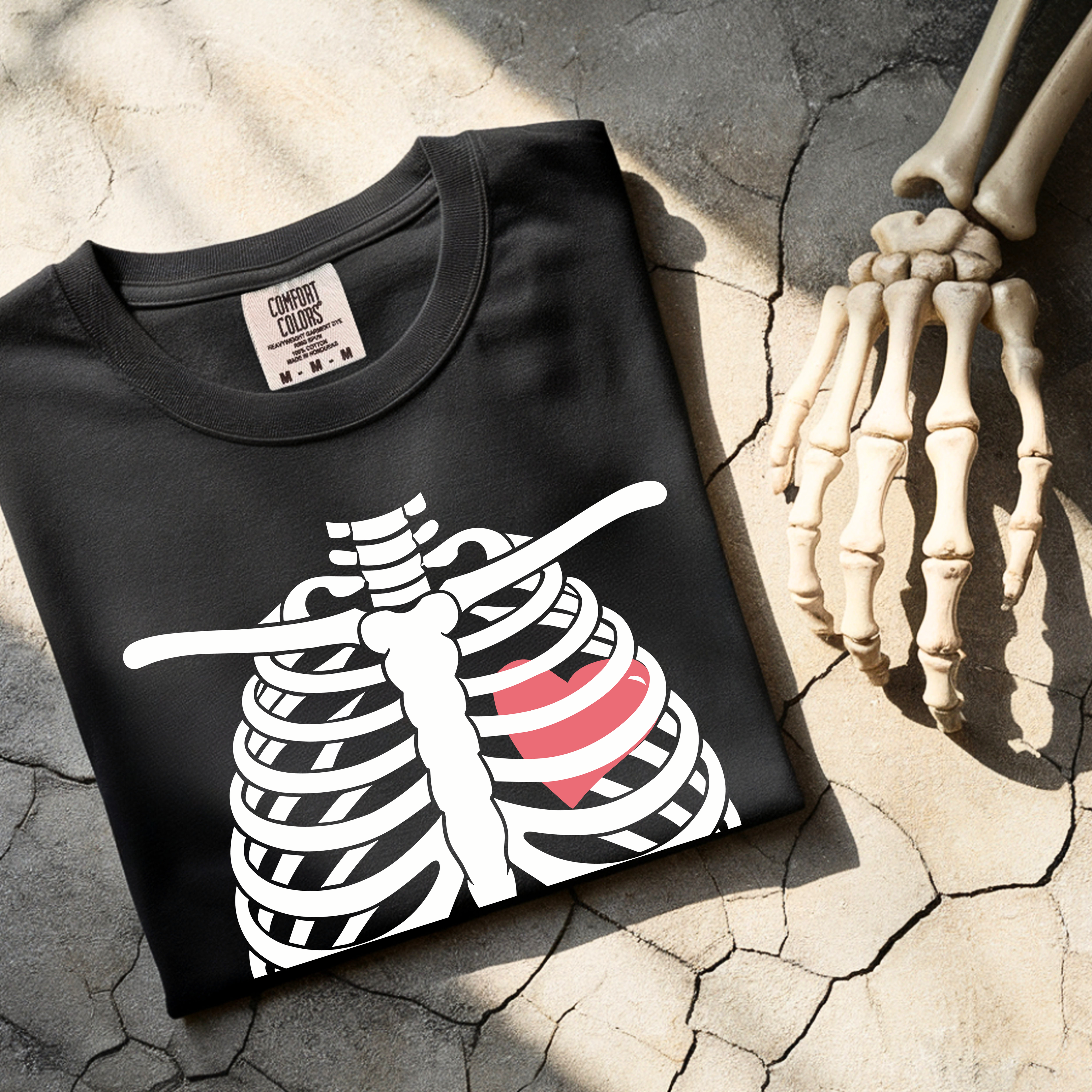 Folded Halloween pregnancy reveal shirt with skeleton baby bump graphic