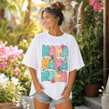 Woman wearing colorful floral mama retro t shirt in a sunny garden, summer mom graphic tee with vintage floral design.