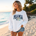 Woman wearing white Mama Nautical sweatshirt featuring ship wheel and starfish design while walking on a tropical beach.