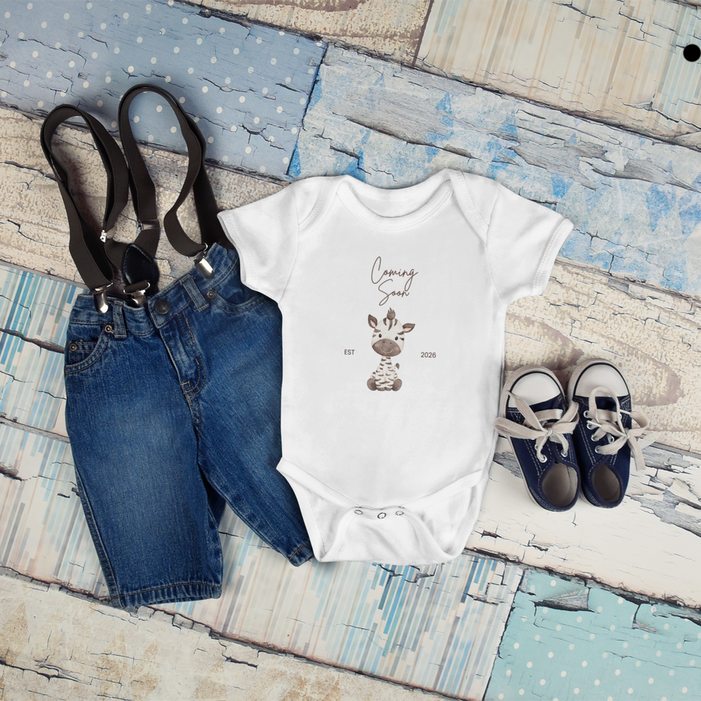 cute coming soon baby onesie flat lay with baby accessories perfect for pregnancy reveal