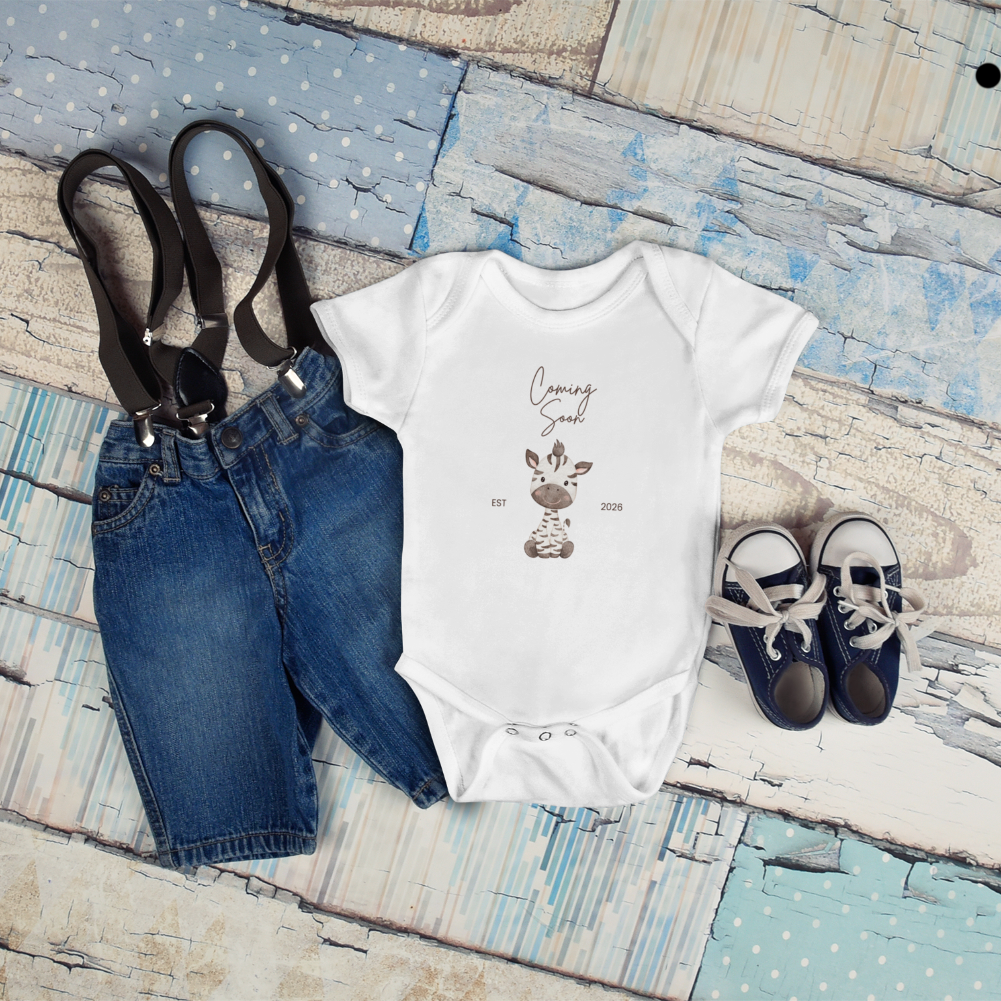 cute coming soon baby onesie flat lay with baby accessories perfect for pregnancy reveal